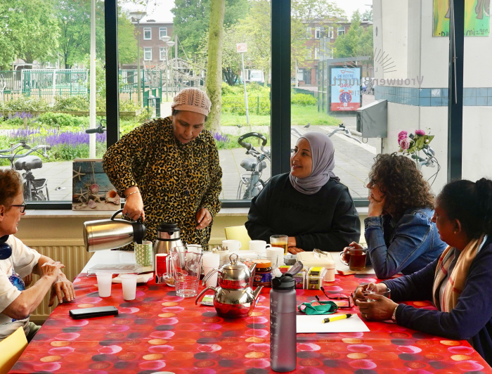 Vrouwenbuurtlab in Spoorwijk drinken koffie aan tafel