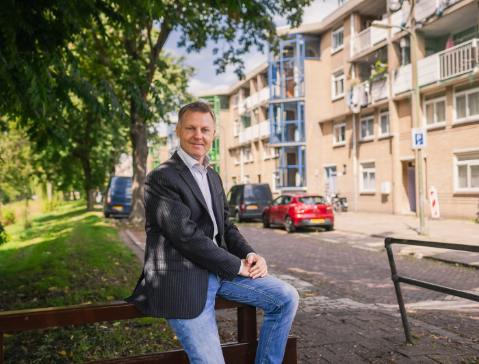 Gijsbert van Herk half zittend op hek in de wijk