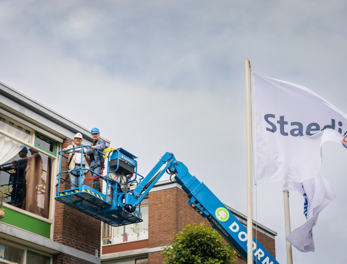Gijsbert van Herk en Olaf de Lange samen in de hoogwerker om een vleermuiskast op te hangen