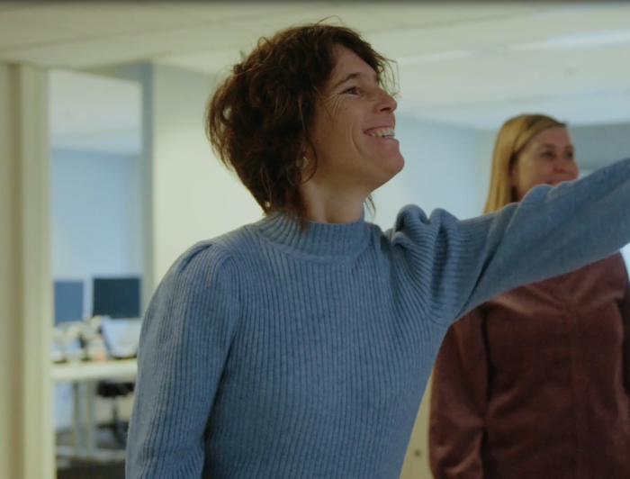 Annelies wijst iets aan aan collega