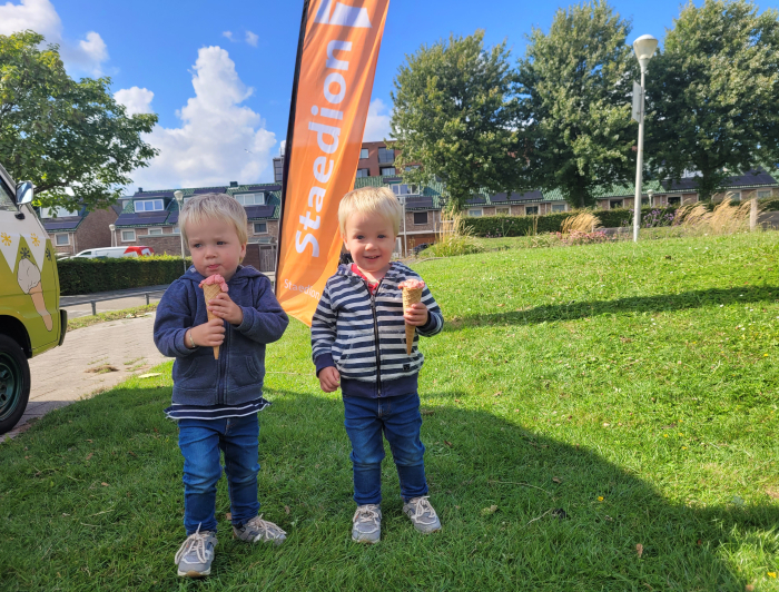 Twee kinderen smullen van een gratis ijsje