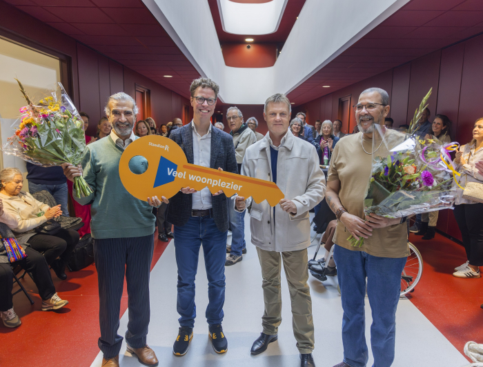 De eerste bewoners ontvangen de symbolische sleutel van hun nieuwe huis