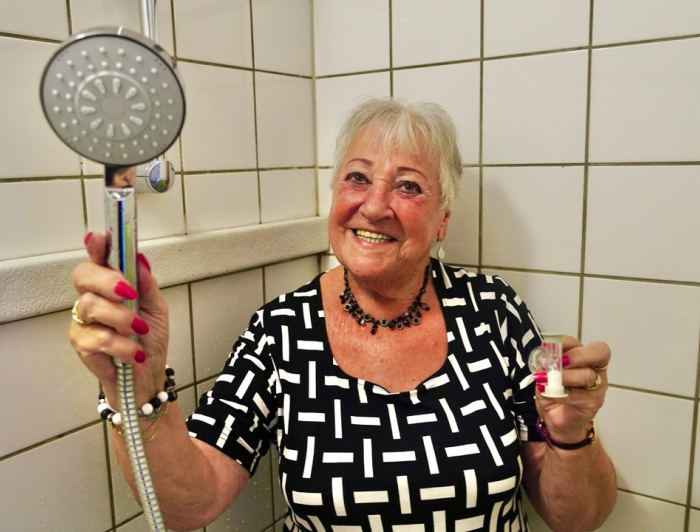 Janette met een douchekop in haar handen