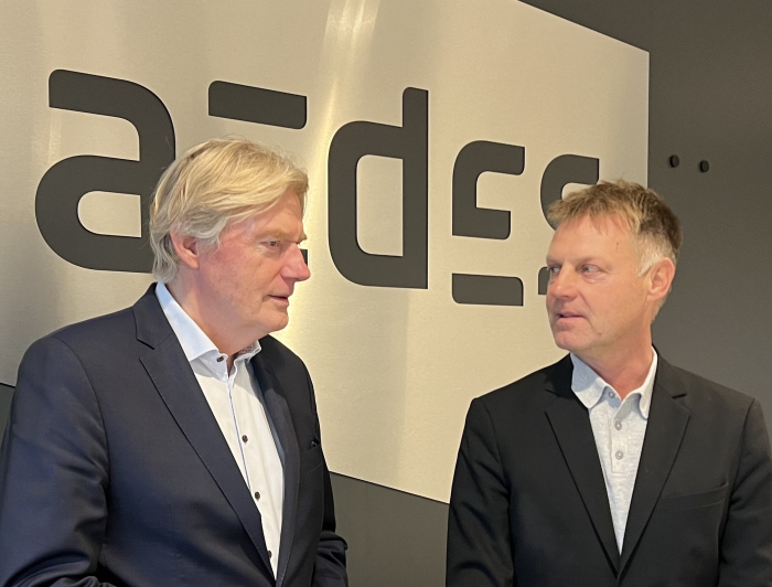 Martin van Rijn en Gijsbert van Herk voor een bord met Aedes
