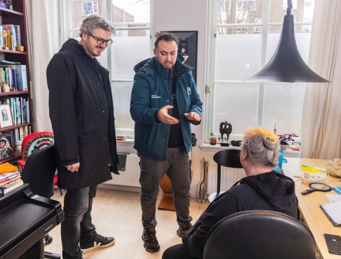 Wethouder Kapteijns en een bewoner krijgen tips voor energie besparen van enrgiefikser Achraf