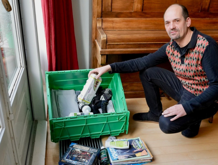 Jelle van spullenbak plaatst een eierdoos in een groene bak