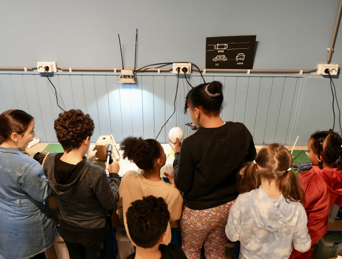 Een groep kinderen aan het werk aan een hoge tafel in het MuseumLab Zicht