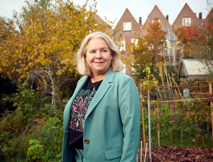 Antoinette gebiedsregisseur staat in een groene tuin de Spinozahof