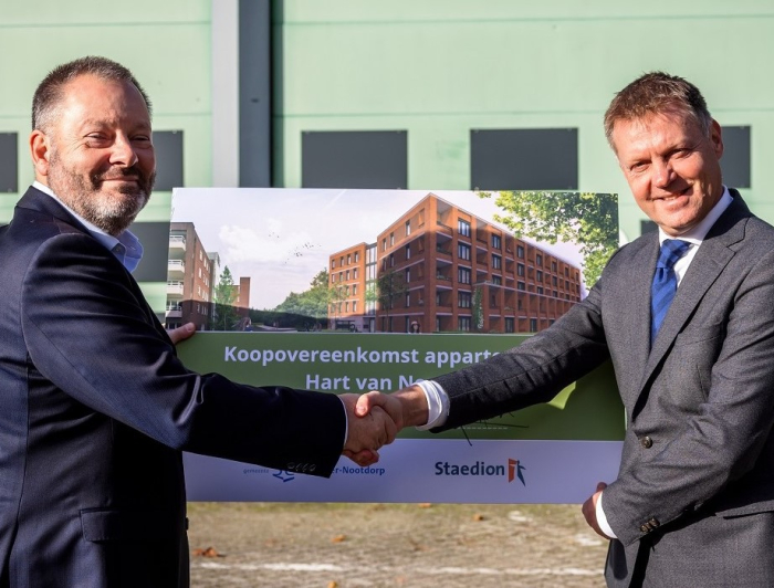 Gijsbert en Wethouder van Kuppeveld schudden hand en houden een bord van het project in hun hand