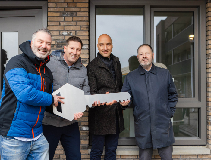 Een uitvergrootte sleutel van het appartementengebouw wordt in ontvangst genomen