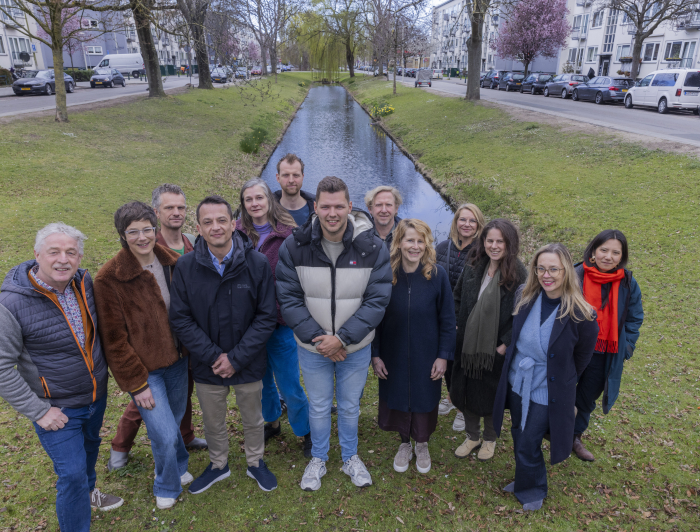 De ontwerpers van Studio Corvers, Overtreders W en Anne van Strien en Daniela Tokashiki gezamenlijk op de foto bij een groenstrook en water in de wijk