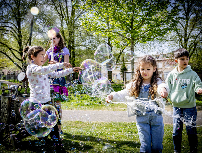 Kinderen spelen buiten met bellenblaas tijdens de feestelijke start van BRUIS