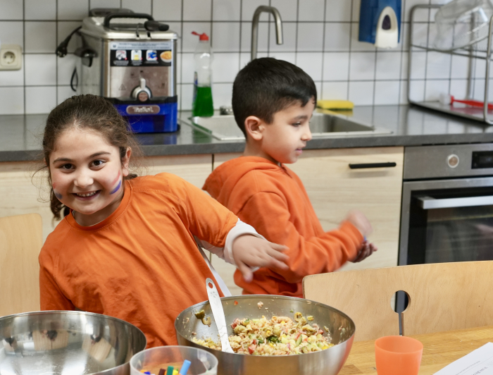 Twee vrolijke kinderen in de keuken