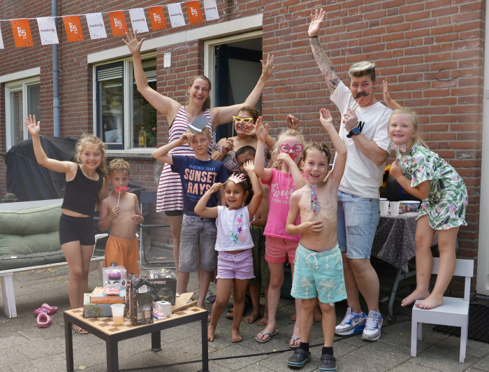 Kinderen in de Dr. J. Presserstraat die met hun handen in de lucht staan uit blijdschap