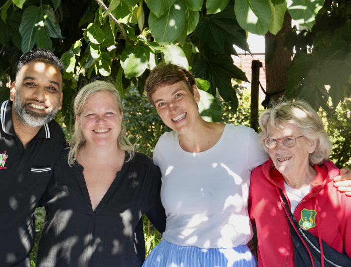 Een meneer en drie dames op een rij onder de boom