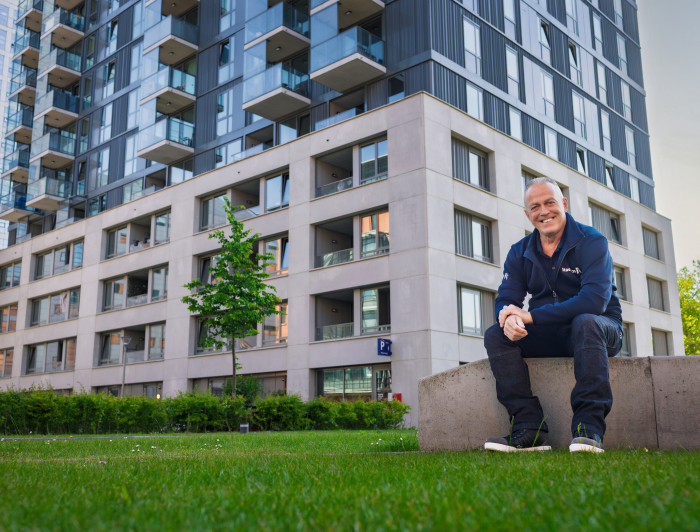 Peter trots zittend voor 'zijn' gebouw