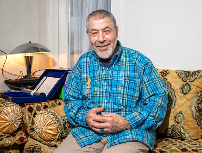 Hassan zit op de bank in zijn woning in Transvaal