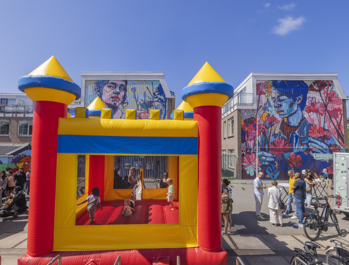 Een springkussen met daarop kinderen en eromheen volwassenen