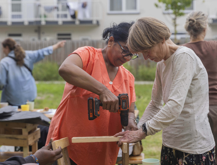Twee dames maken samen een plantenbak voor aan het balkon