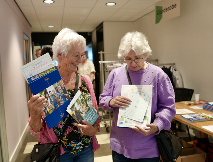 Twee dames op de Woonfitmarkt pakken wat folders