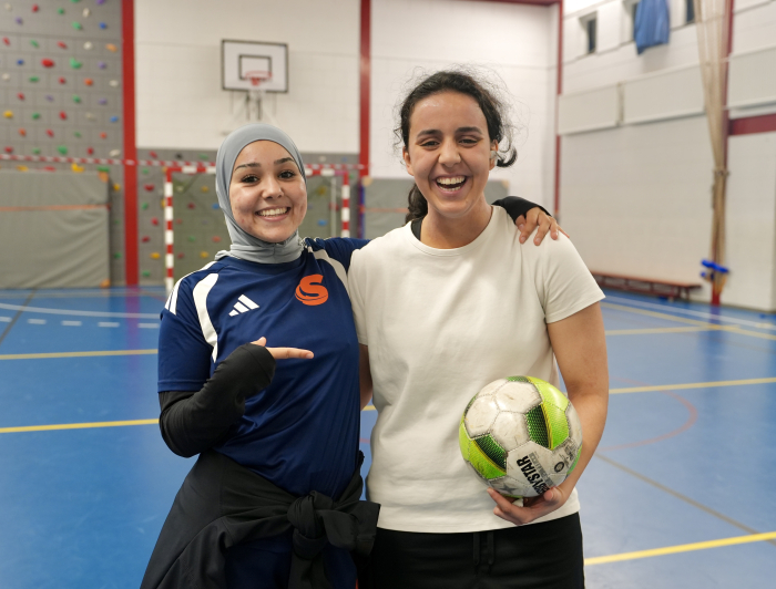Twee meisjes in een sporthal met een bal in hun hand